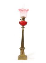 A 19TH CENTURY BRASS AND CRANBERRY GLASS OIL LAMP