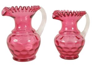 A GRADUATED PAIR OF 19TH CENTURY STYLE OVERSIZED CRANBERRY GLASS JUGS