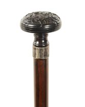 A 19TH CENTURY CARVED EBONY AND CALAMANDA WALKING CANE