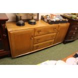 Ercol Blonde Elm Sideboard of 3 drawers flanked by Cupboards. mounted on casters