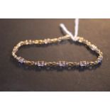 Ladies 9ct Gold tennis bracelet set with 10 Tanzanite's in claw settings and semi facetted