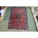 Persian Red ground carpet with floral borders and central medallion 130 x 80cm