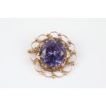 Ladies Early 20thC Yellow gold scroll design brooch inset with large facetted synthetic Sapphire