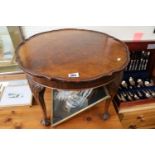 Walnut quartered veneered low table with piecrust top over ball and claw feet