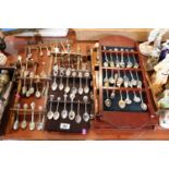 Collection of Silver plated Souvenir spoons on wooden racks