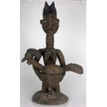 A Yoruba (Nigerian) female figure holding a figural offering bowl with chicken 68cm high.