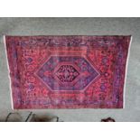 Good Quality Persian red ground rug with central medallion 228cm in Length