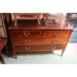 Edwardian Chest of 2 over 2 drawers with brass drop handles and tapering legs terminating on casters