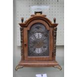 Wuba Warmink Oak cased mantel clock with metal roman numeral dial, supported on brass bract feet