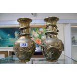 Pair of Chinese Antique Brass vases decorated with Dragons amongst clouds character marks to base.