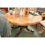 Oval Walnut topped Quartered Veneered table with Tilt Top on carved out swept feet and ceramic