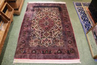 Good quality Red Ground Persian Silk Rug with central medallion and floral borders and tassel end