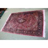 Good quality Silk Red ground rug with central medallion and tassel ends 218cm x 139cm