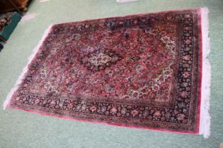 Good quality Silk Red ground rug with central medallion and tassel ends 218cm x 139cm