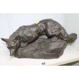 After Bartelier: A bronzed figure of a fox crouching on a rock, signed. 40cm in Height