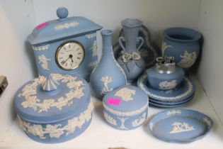 Quantity of blue and white wedgwood jasperware to include clock, pin dishes, table lighter etc