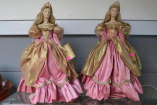 Two Franklin Heirloom Bisque Porcelain Dolls of princesses in pink with tiaras, on stands.
