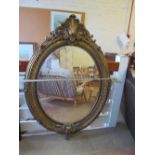 A large oval gilt mirror
