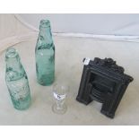 A miniature fireplace and two glass bottles