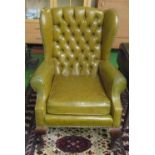 A button back armchair upholstered in green leatherette
