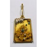A heavy gold coloured pendant with nugget, pearls, green stones and turquoise