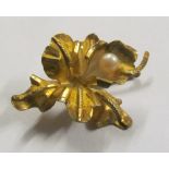 A gold coloured flower brooch