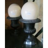 Two cast iron urns with ostrich eggs