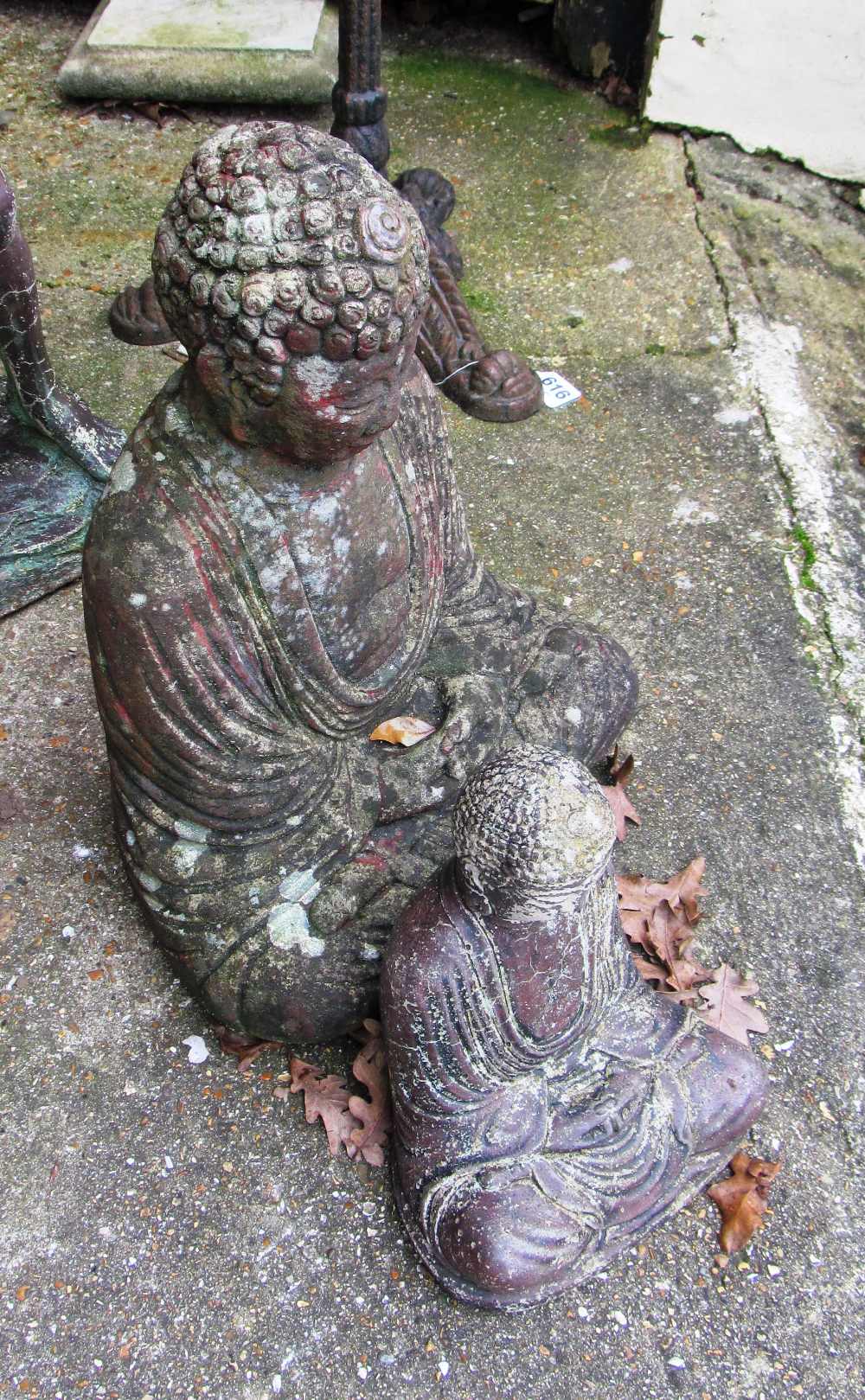 A stoneware garden buddah and another smaller