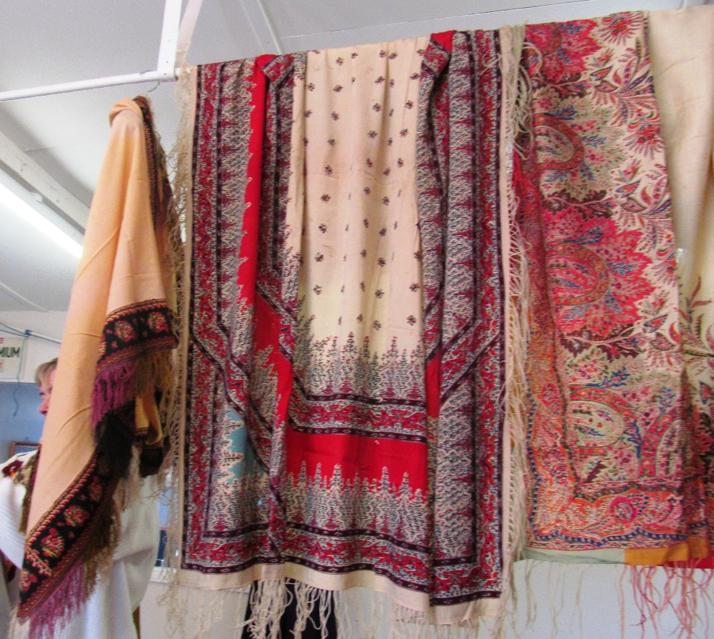 Three antique textiles, two with floral prints, one with embroidered edges and all with tassel
