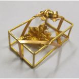 A gold coloured cage pendant central flowerhead and pearl