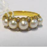 A five stone pearl and diamond chip ring on 18ct gold band