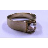 A gold coloured single stone ring marked 750, size U/V