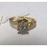 A 9ct gold cluster ring with diamond shoulders marked 0.50 on band