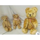 A vintage small golden plush teddy bear and two other smaller bears