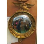 A gilt convex ball frame mirror with ealge mount