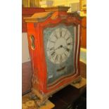 A large continental red clock with weight movement
