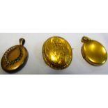 A yellow metal locket dated 1873 and two other lockets