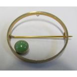A 15ct gold circular brooch set single jade stone