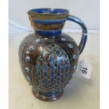 A Doulton Lambeth jug with mask head to top (repair to rim)