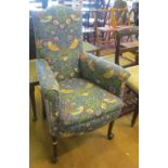 A 1920's high back armchair upholstered in William Morris style fabric