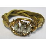 A 19th Century plaited hair? bracelet with pretty engraved clasp inset three oval crystals