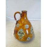 A Doulton Lambeth jug brown ground with blue green symmetrical design maker Louisa Wakely (no
