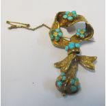 A gold coloured brooch set turquoise flowerheads and pear drop