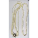 A triple strand pearl necklace with silver star shaped pearl and white stone clasp and another pearl