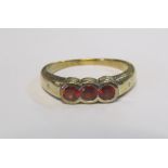 A 9ct gold three stone red ring, 3.2g