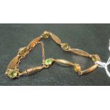 A 9ct gold bracelet set green stones