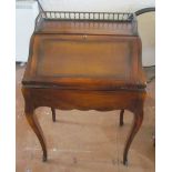 A small French style Bureau de Dame with brass gallery leather inset top and hinged flap revealing