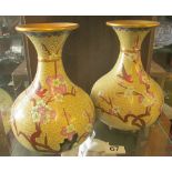 A pair of cream cloisonné vases decorated birds and flowers
