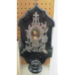 A black marble religious wall shrine with white metal mounts and painted porcelain plaque of