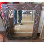 A large Arts & Crafts copper framed mirror with raised stylized leaf design